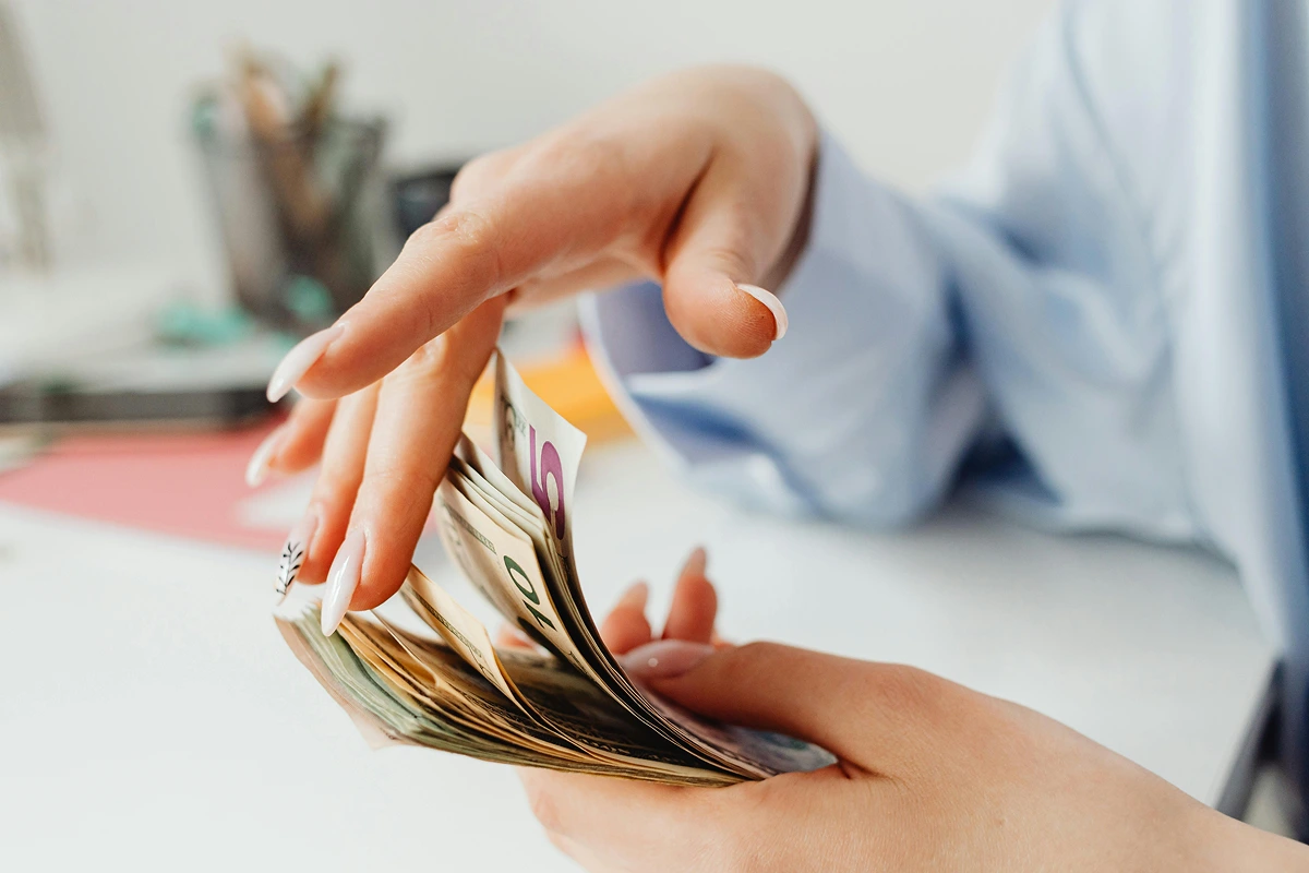 Ondernemer met cash in haar hand omdat ze geld bespaard bij PayPacker